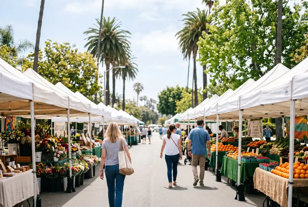 Sunny farmers market stalls with produce under white canopies on a Los Angeles Westside street