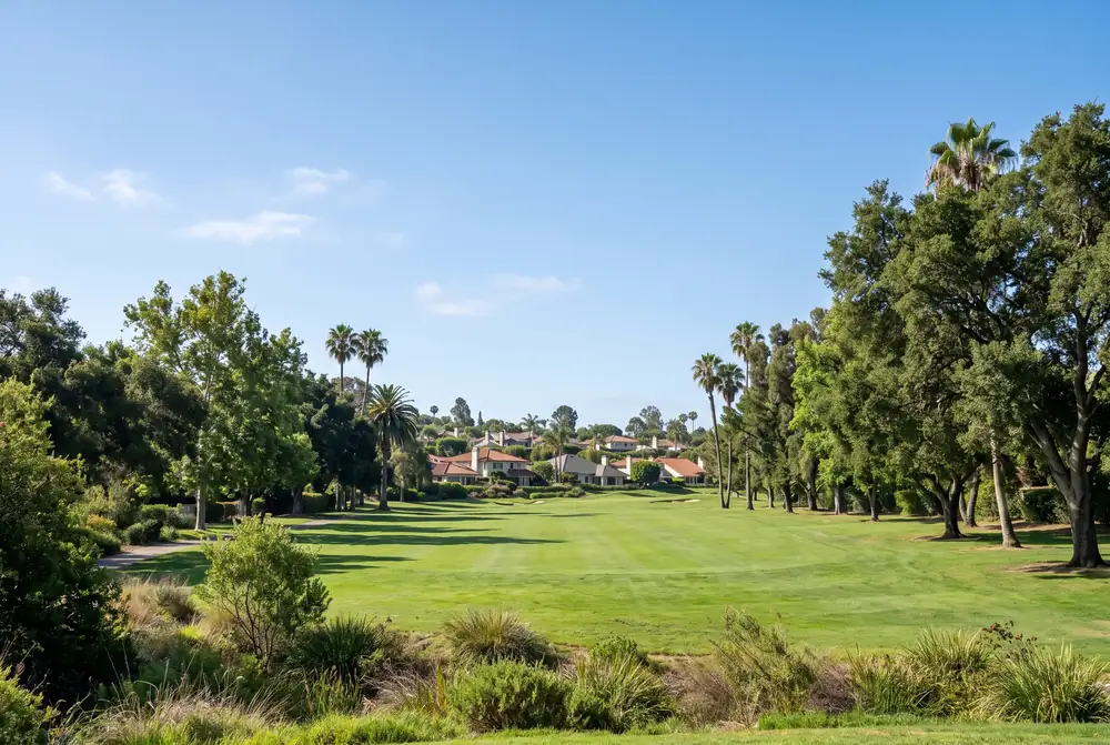 Green public golf course fairway bordered by tall trees and homes in a Los Angeles Westside neighborhood